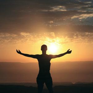 Picture of someone with their arms outstretched looking at the horizon